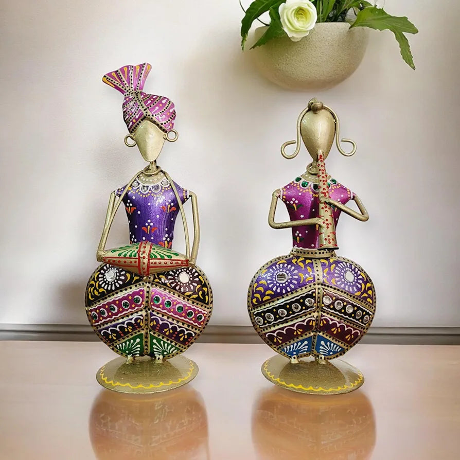 Two ornate figurines with intricate designs on a reflective surface.