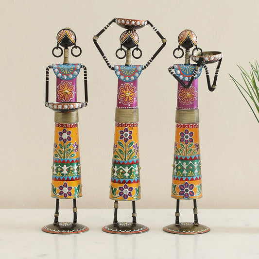 Three colorful decorative statues on a plain background