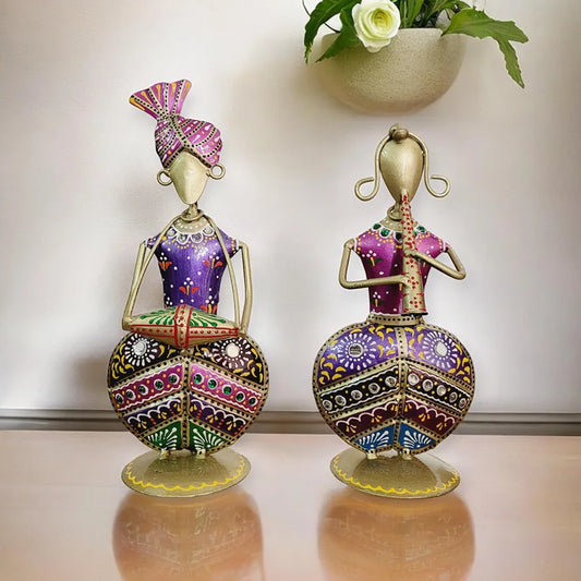 Two ornate figurines with intricate designs on a reflective surface.