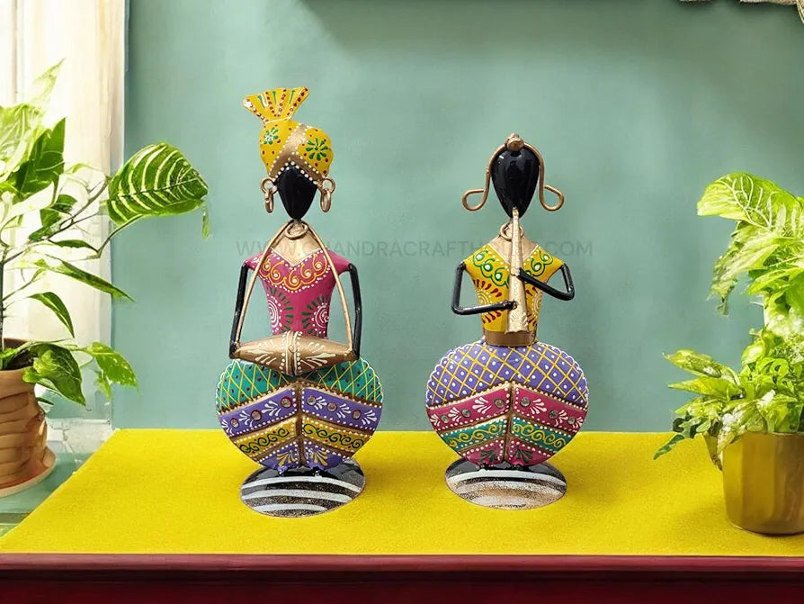 Decorative statues on a yellow surface with a green wall in the background