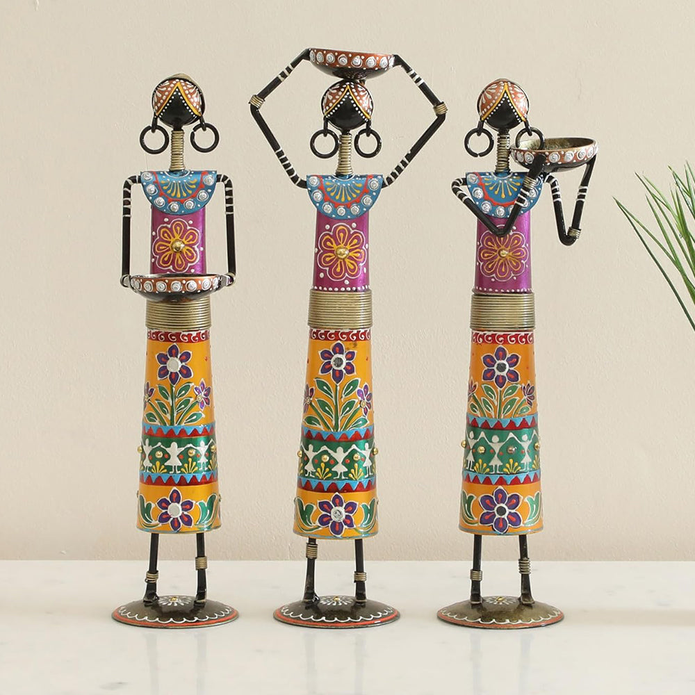 Three colorful decorative statues on a plain background