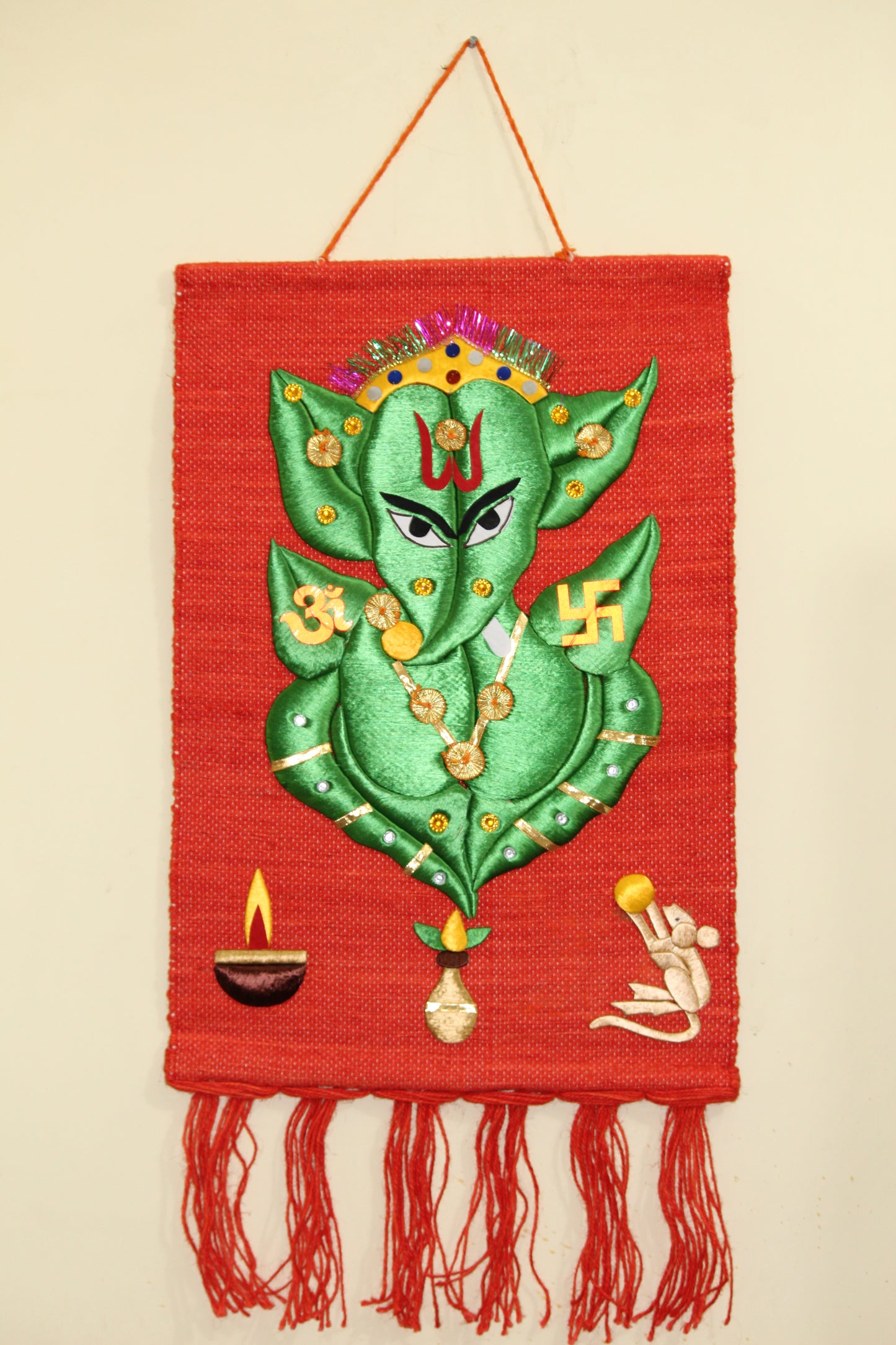 Vibrant orange and green silk embroidered traditional Ganesha wall hanging by Jutetique Krafts