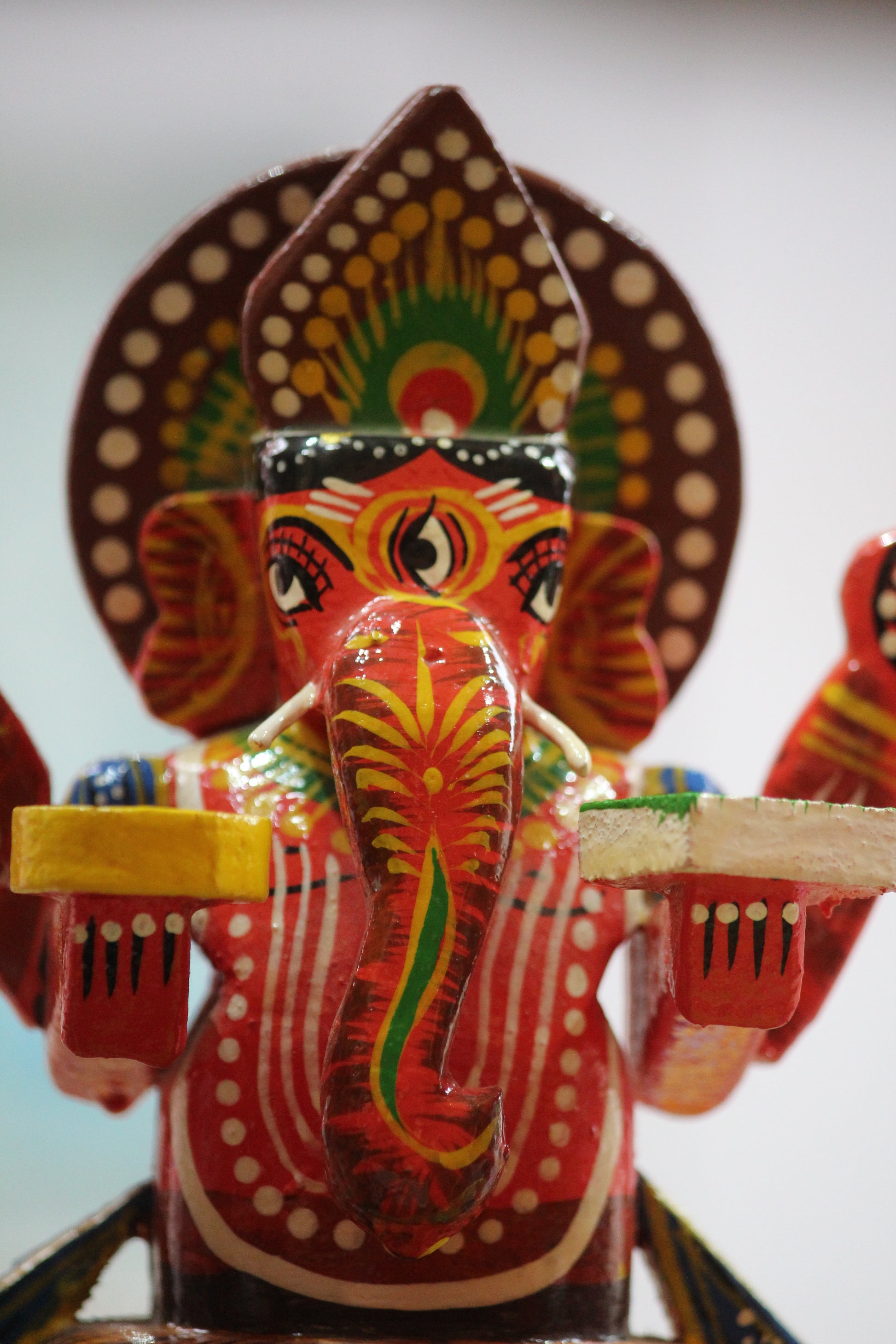 Detailed front view of hand-painted lacquer finish on authentic Banaras wooden Ganesha idol