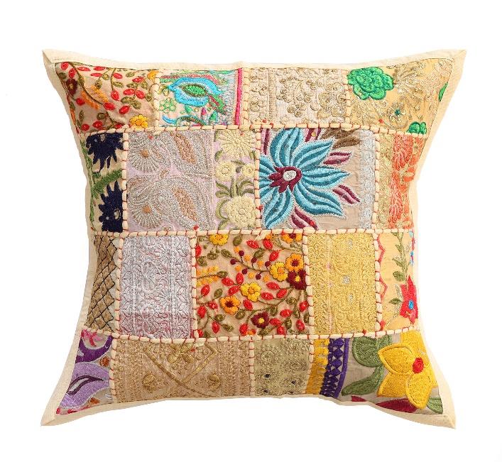 Colorful patchwork pillow with floral patterns on a white background