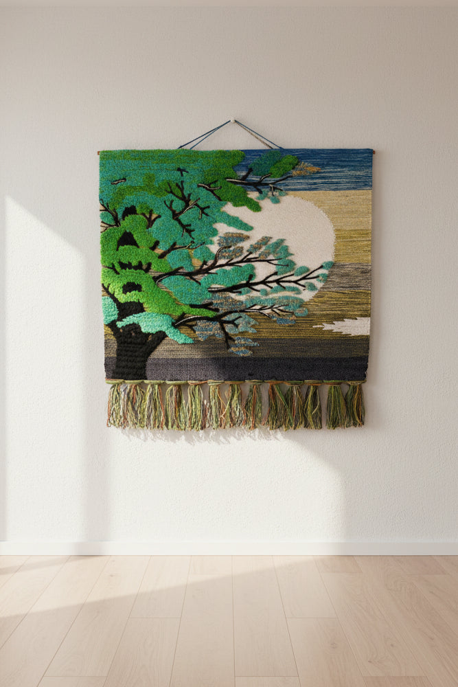 Handmade 30 inch woolen tree tapestry named The Solar Arboreal Wall Hanging, featuring a detailed woven tree silhouette against a green and cream sun horizon background with fringes, hanging on a white wall.