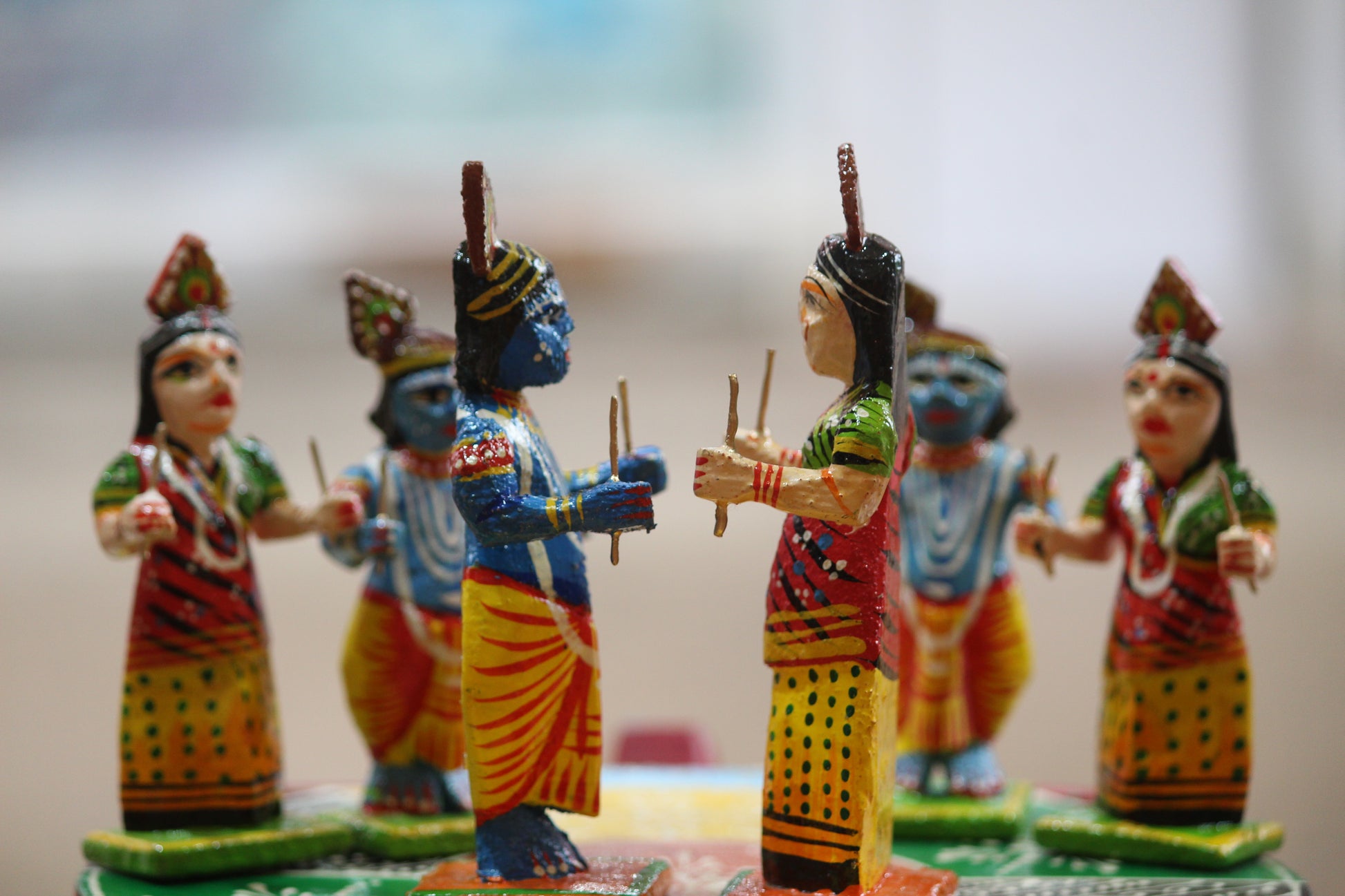 High-gloss friction-based lacquer finish on handmade Kashi wooden figurines by Kunder Kharadi artisans.
