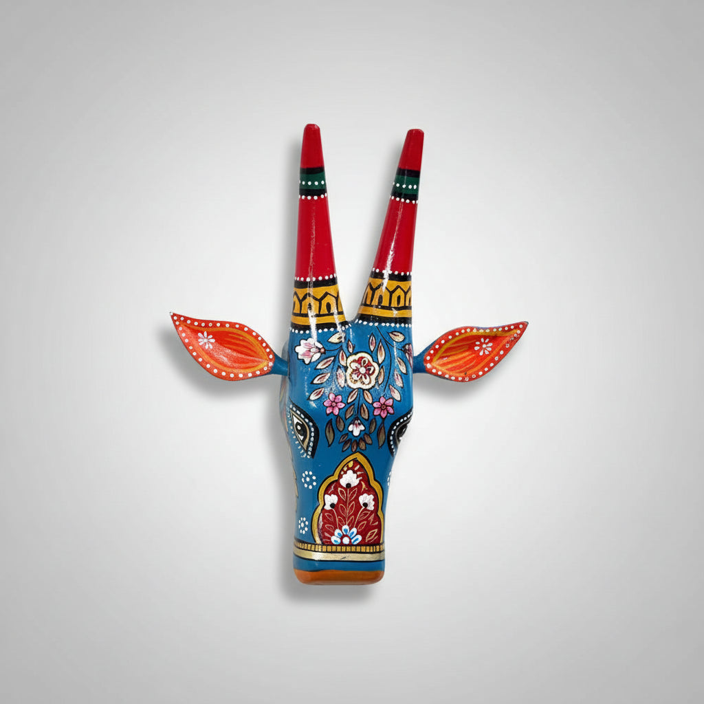 Hand-painted blue wooden cow head wall decor featuring traditional Indian floral patterns and colorful horns.