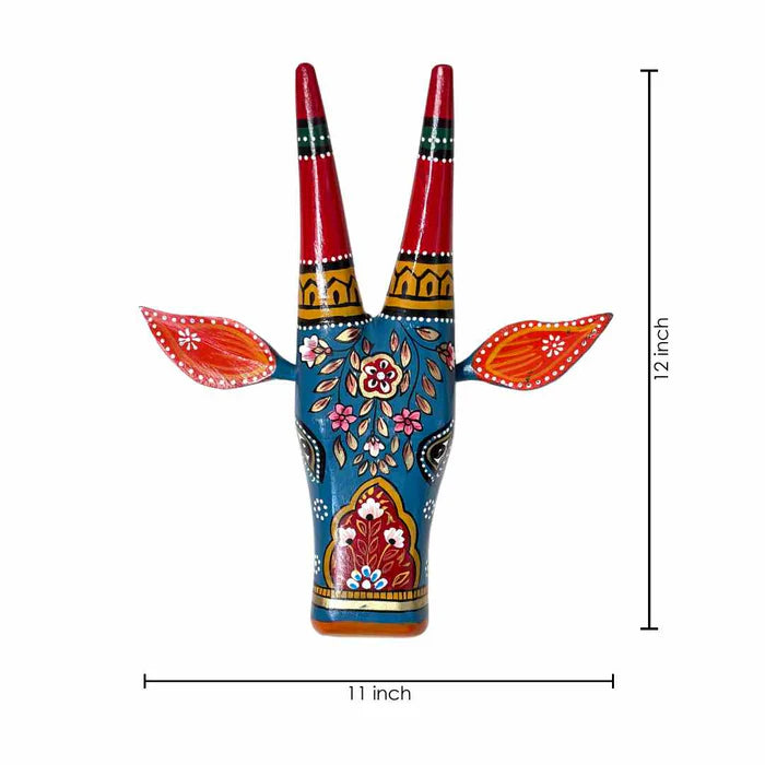 Hand-painted blue wooden cow head wall decor featuring traditional Indian floral patterns and colorful horns.