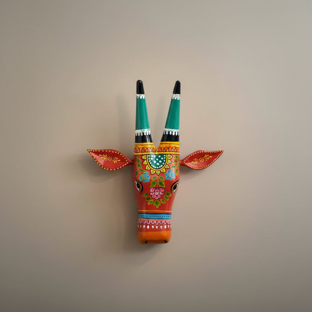 Hand-painted red wooden cow head wall decor featuring traditional Indian floral patterns and colorful horns.