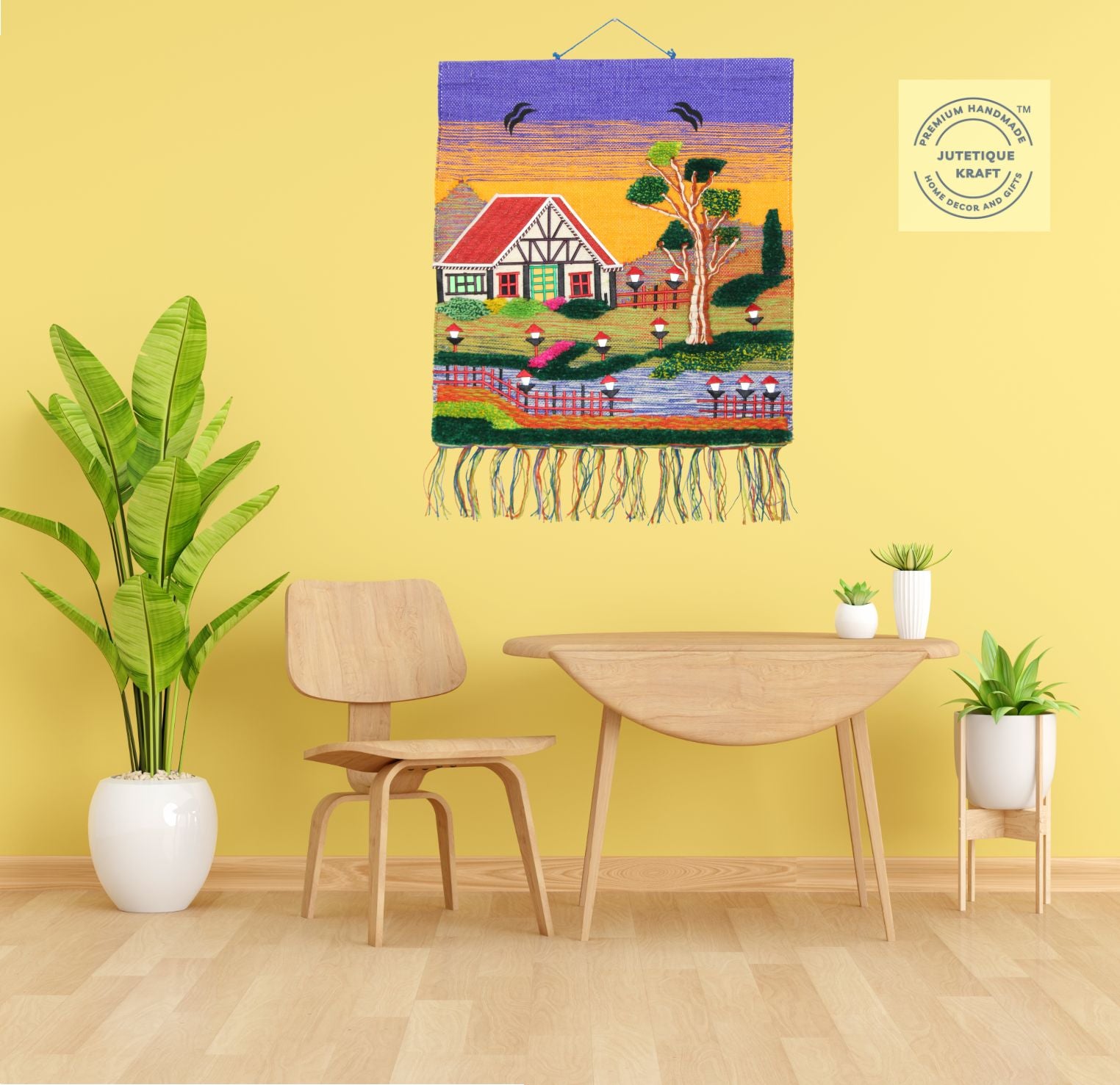 30 inch square GI Tagged jute wall hanging showcasing a rural village cottage scene with a blue sky background