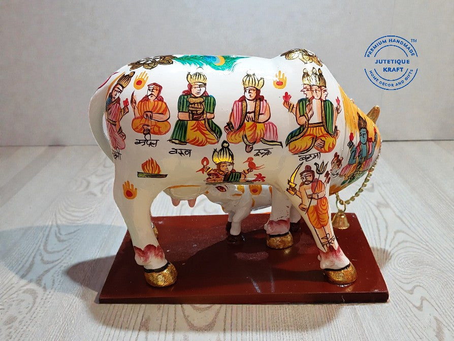 Decorative cow figurine with colorful patterns on a wooden base