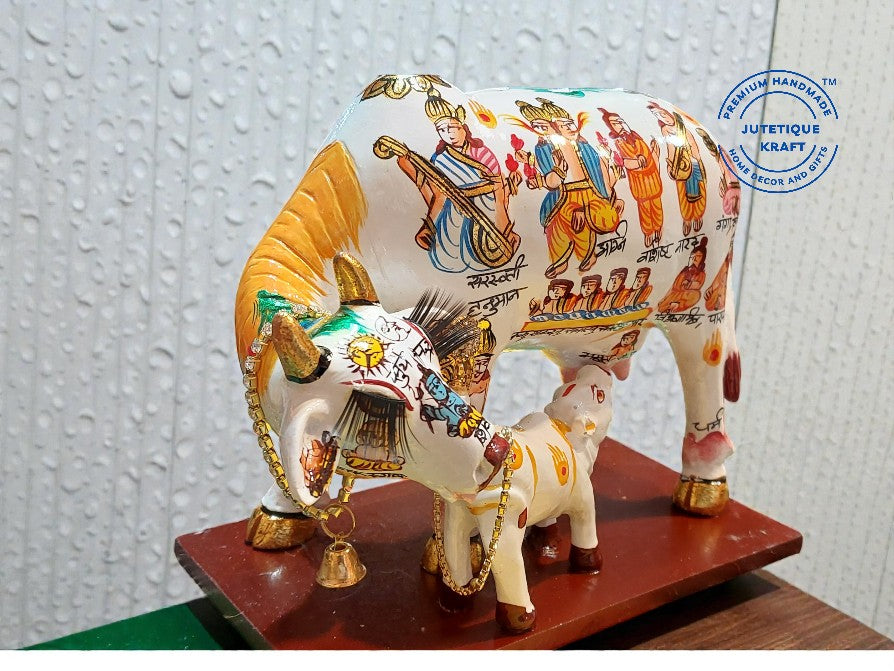Decorative cow figurine with colorful designs on a textured white background