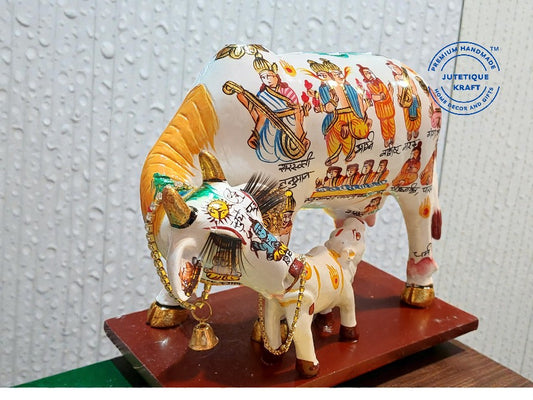 Decorative cow figurine with colorful designs on a textured white background