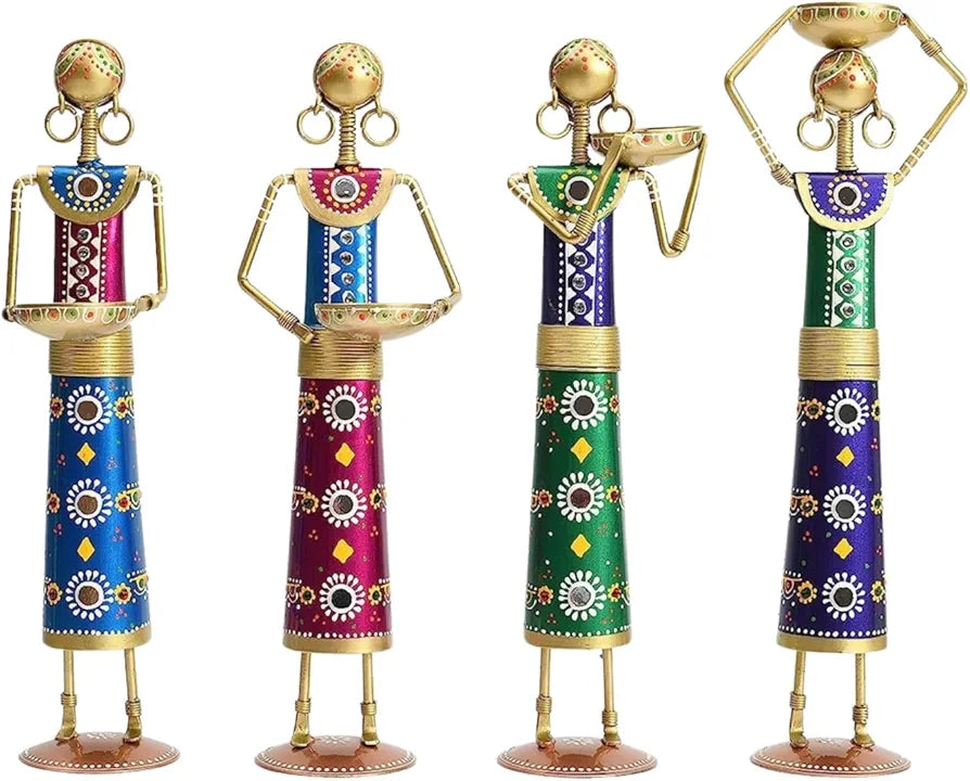 Set of four artisanal blue metal candle holder figurines on a minimalist background