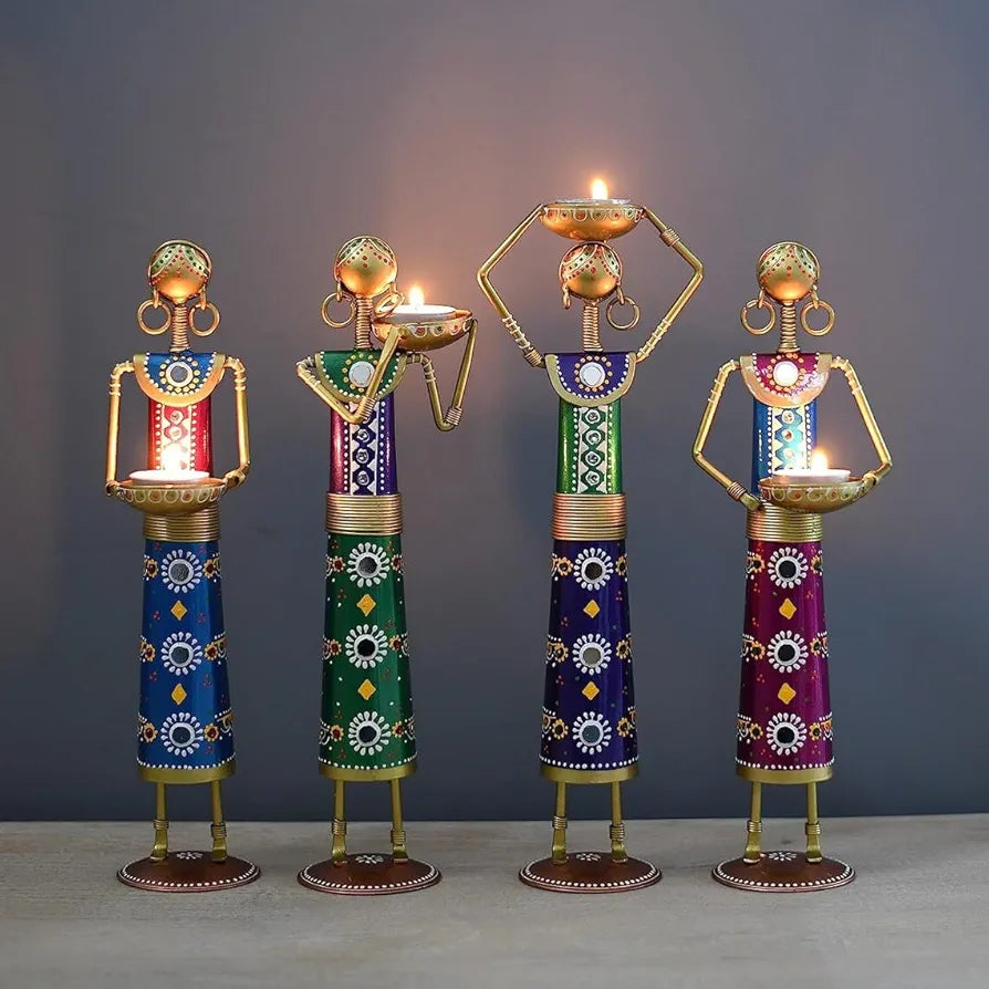 Set of four artisanal blue metal candle dolls holder figurines on a minimalist background