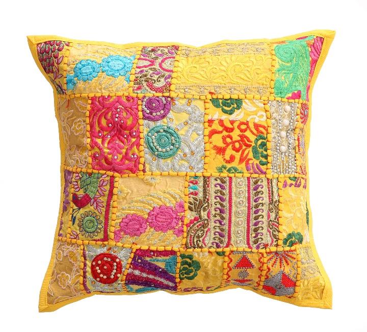 Bohemian style Khambadiya patchwork cushion covers from The Sia Collection displayed on a rattan chair.